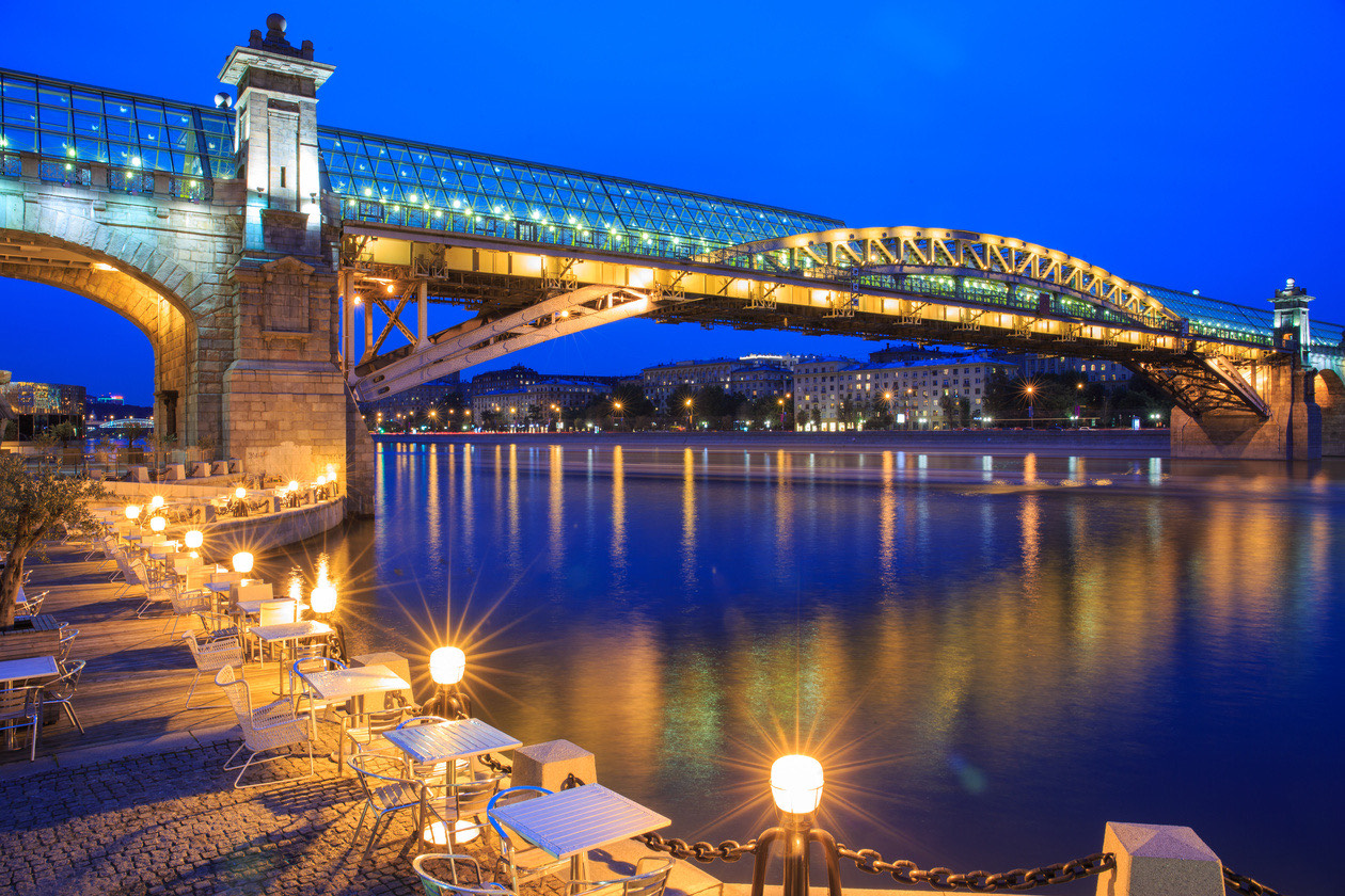 Illuminated bridge over a river at blue hour with lights reflected in the water