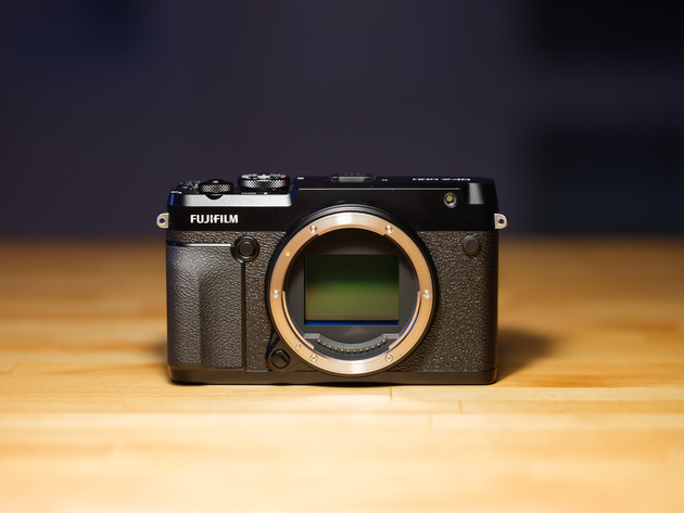 Fujifilm GFX 50R medium format camera body on a wooden table with its sensor exposed