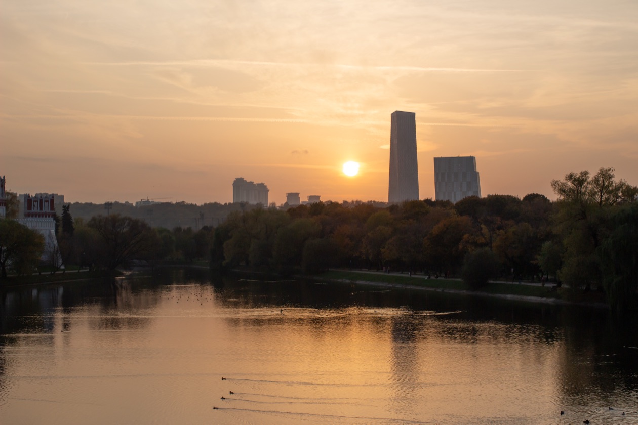 The same sunset over the river with high-rise buildings, without the flare spot