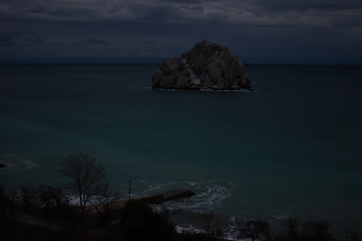 Rock in the sea photographed far too dark, an underexposed frame