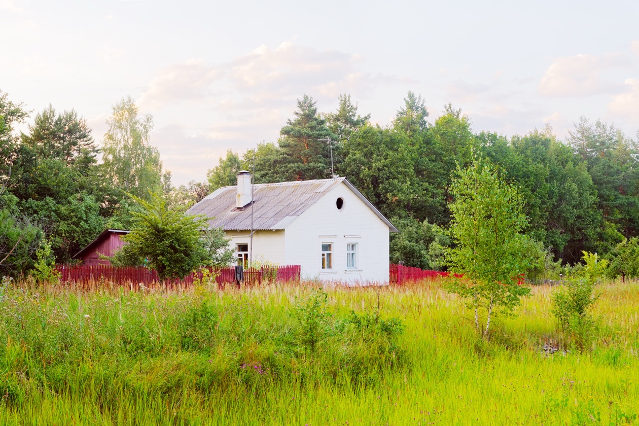 The same house photographed too bright after metering on the dark forest