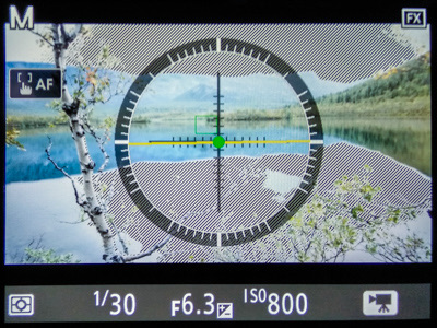 Camera screen in video mode with diagonal stripes over the overexposed sky and water
