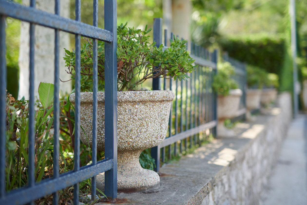 Second version of the flower urn and iron fence shot wide open in bright sun
