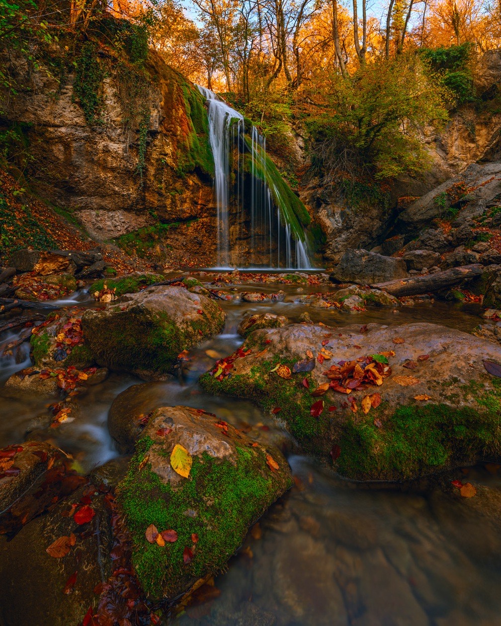 Waterfall in an autumn forest with the falling water smoothed by a long exposure
