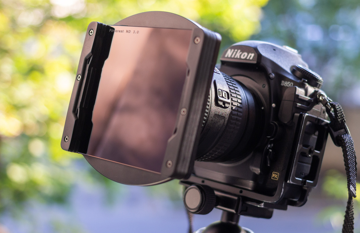 Nikon camera on a tripod with a square ND filter mounted in a holder on the lens