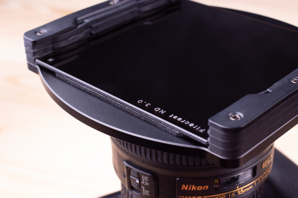 Close-up of a square ND filter slotted into a holder on a Nikon lens