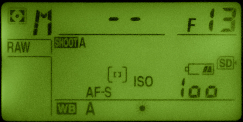 Camera top LCD panel in manual mode showing the Time setting as two dashes at F13 and ISO 100