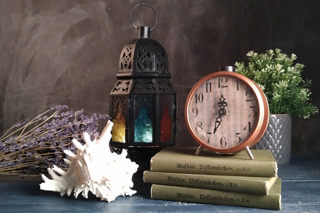 Still life with an alarm clock, a lantern, old books, a seashell and lavender