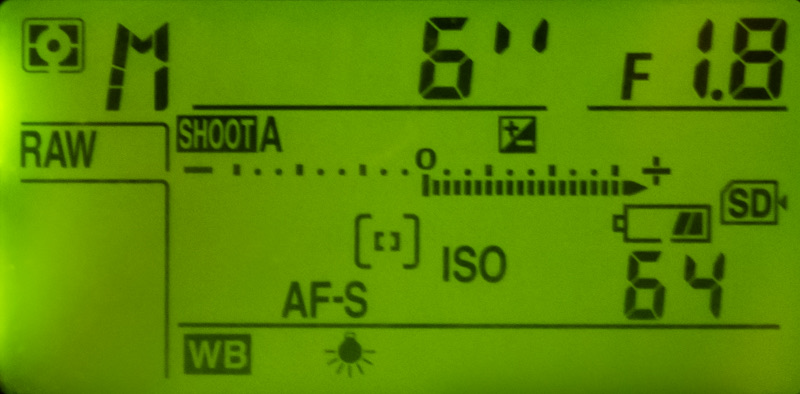 Green-lit top LCD of a DSLR showing 6 seconds with a double-prime mark
