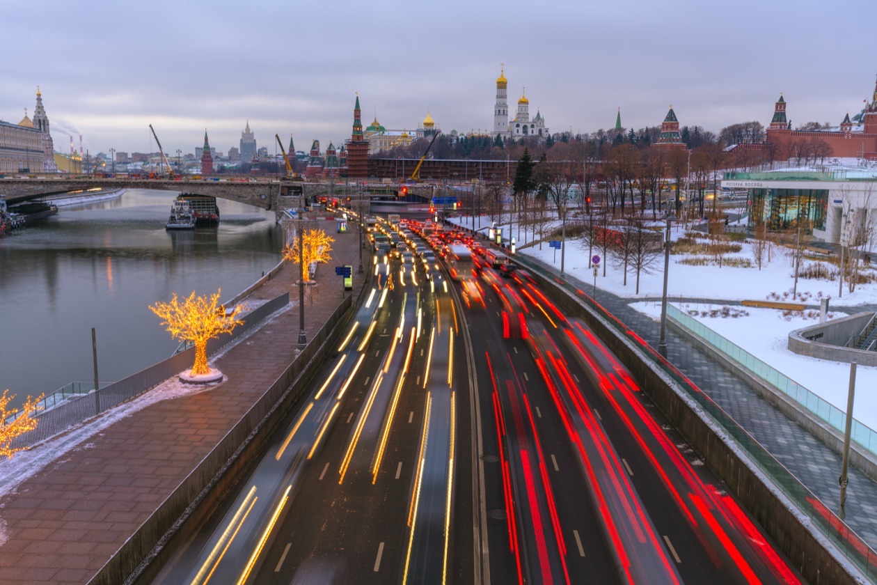 Evening city embankment with red and white light trails from moving cars