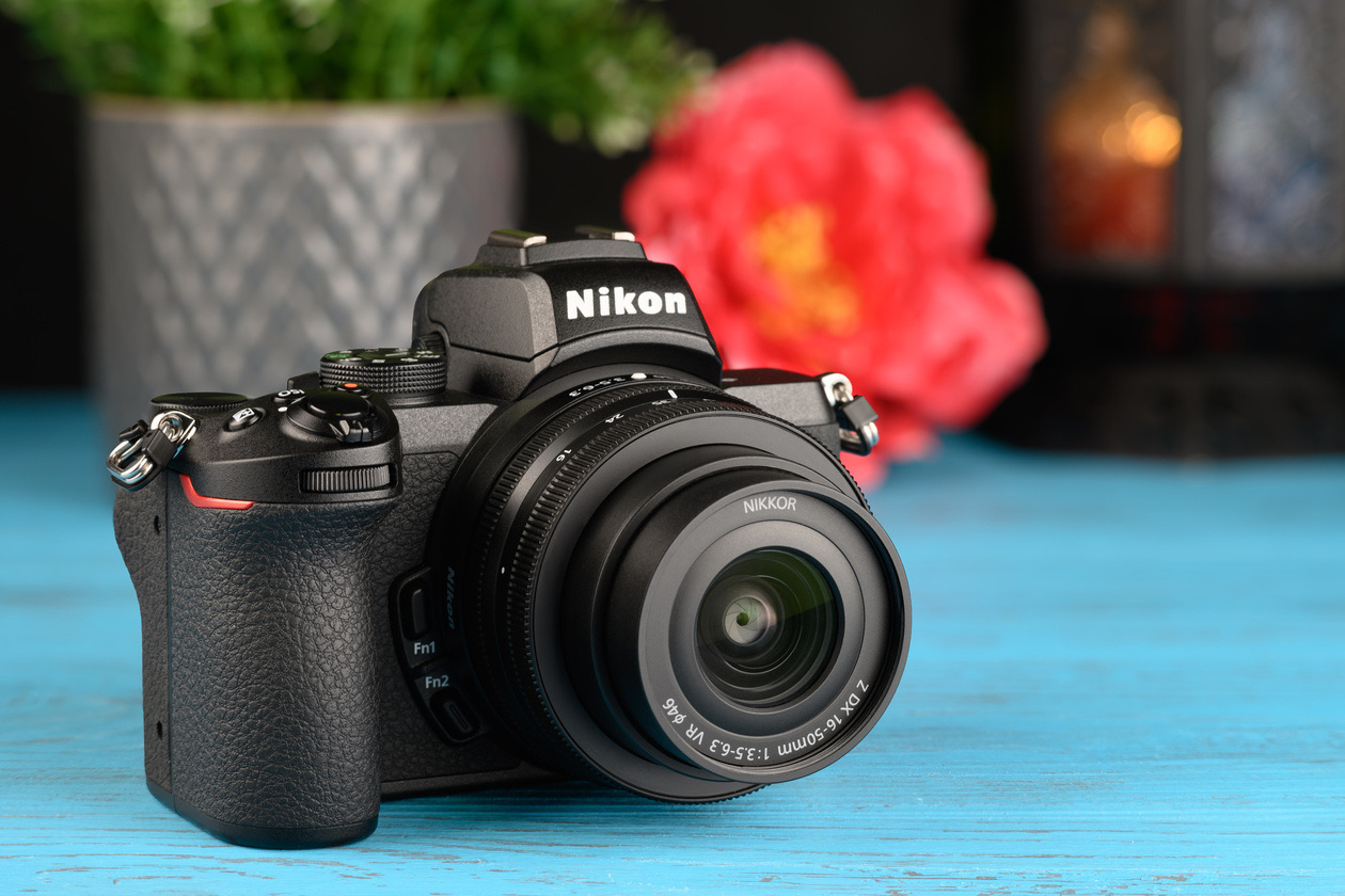 Nikon Z 50 mirrorless camera with its kit zoom lens on a blue table